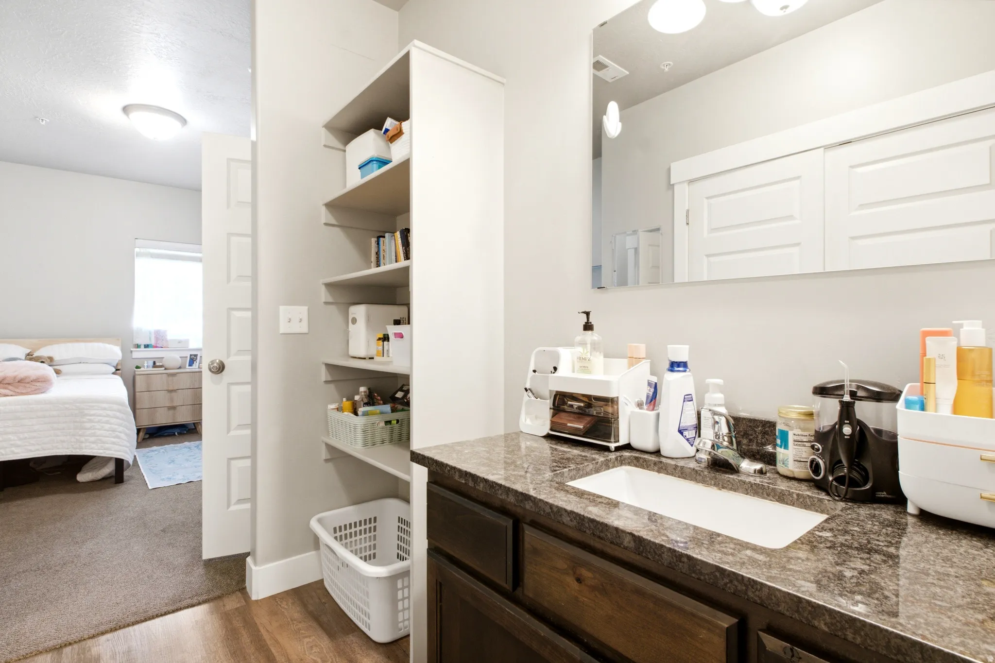 Bathroom vanity with a rectangular undermount sink and a speckled countertop