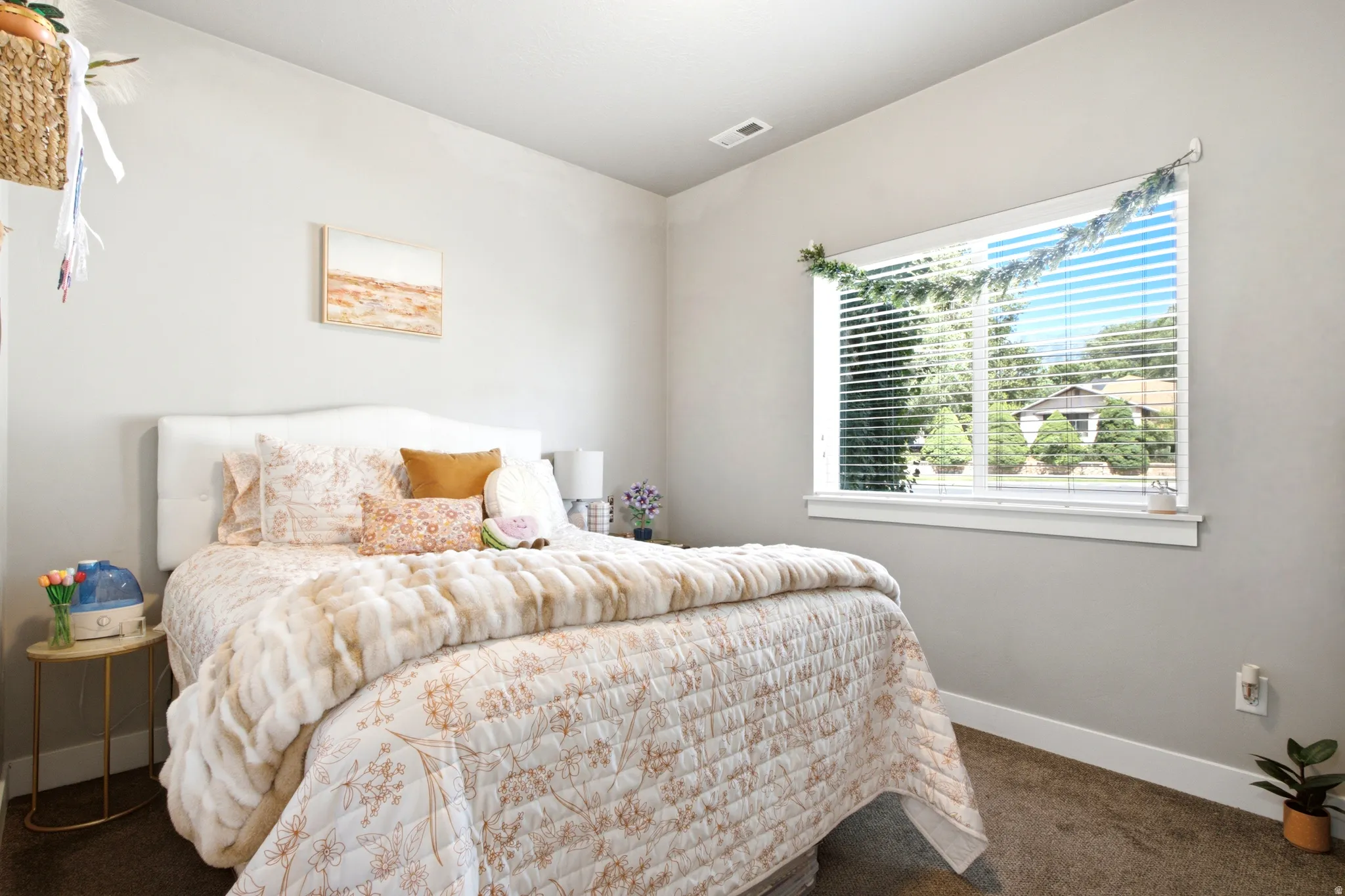 Bedroom featuring a large window, neutral paint, white trim, and carpet flooring