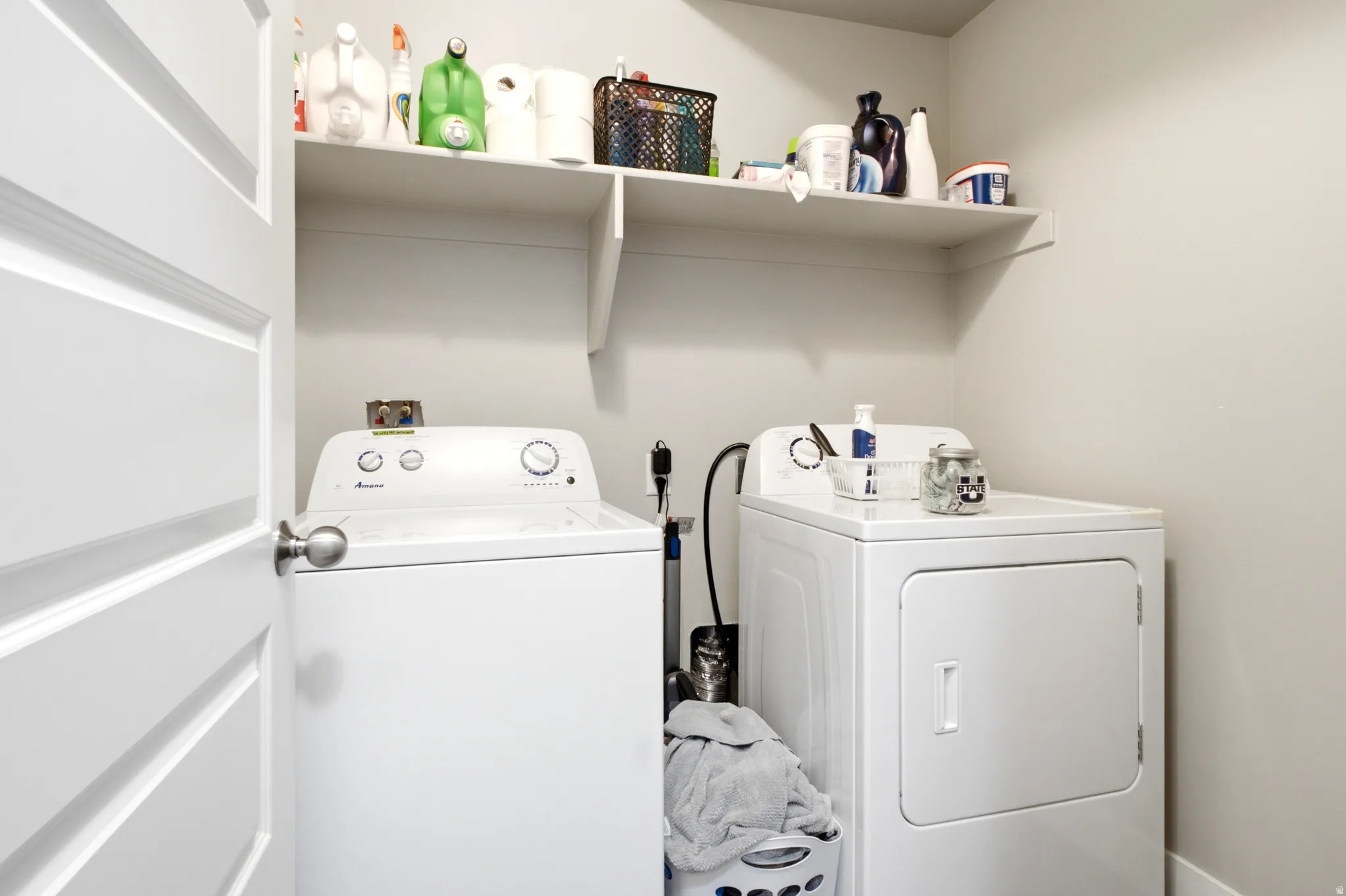 Dedicated laundry area featuring a white top-load washing machine and front-load dryer