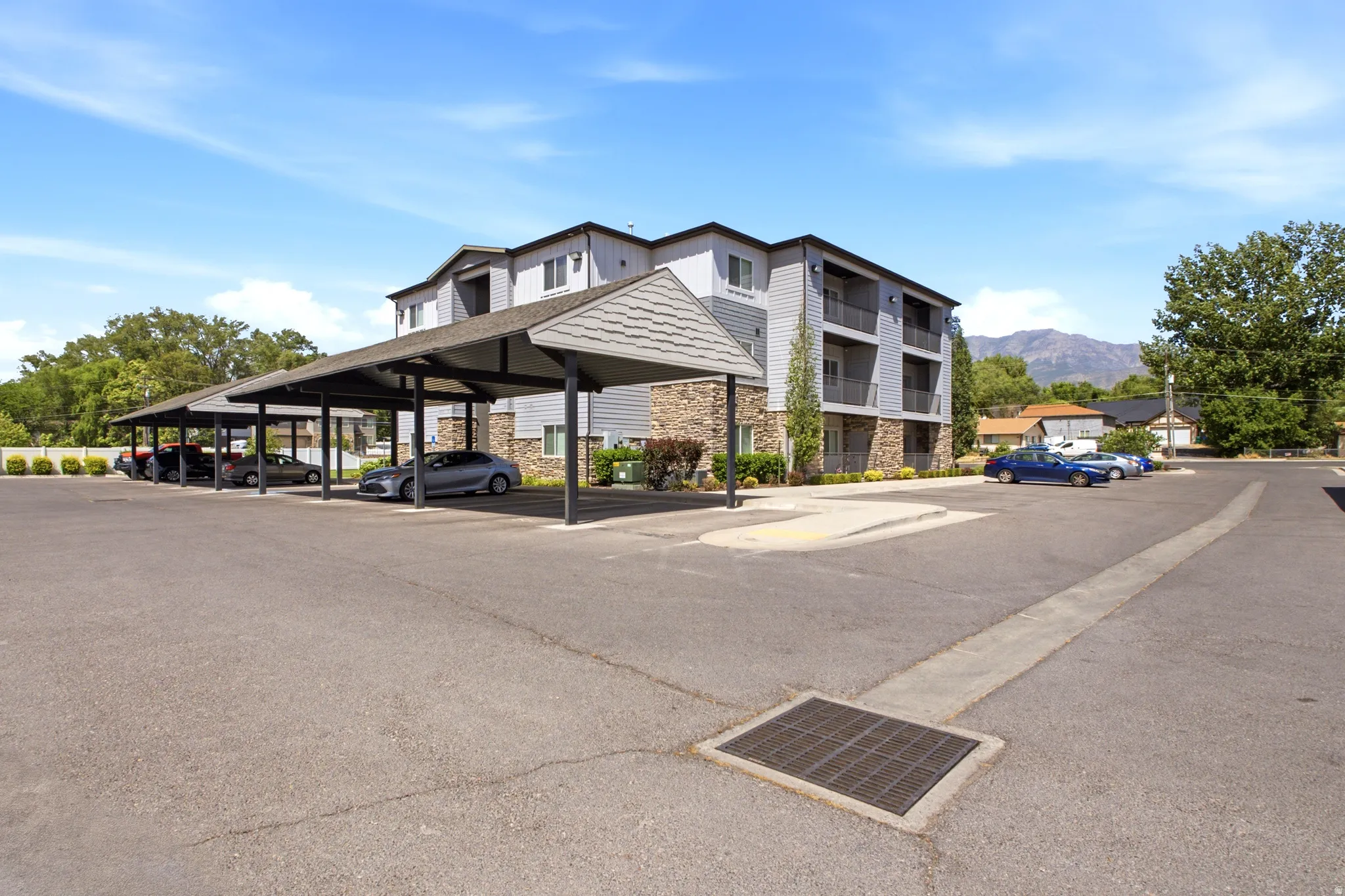 Expansive paved parking area featuring covered carport spaces