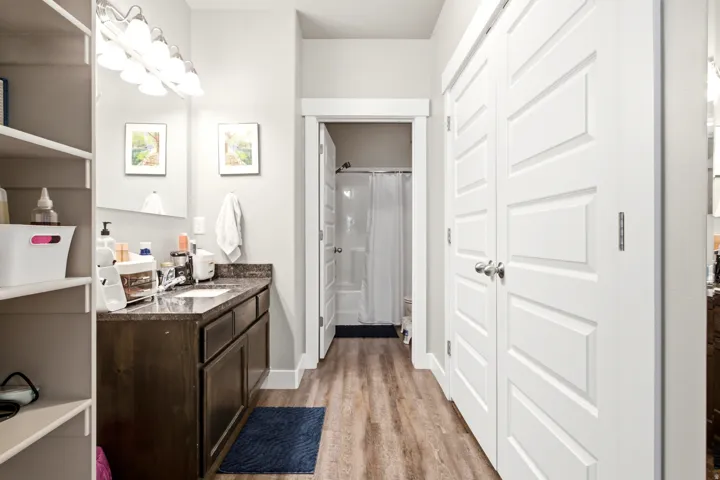 Bathroom featuring a dark wood-finish vanity with a dark countertop, an integrated sink, and a multi-bulb vanity light fixture