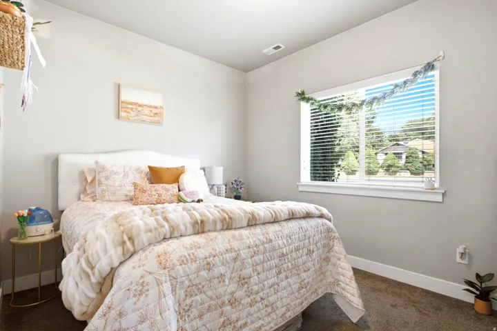 Bedroom featuring a large window, neutral paint, white trim, and carpet flooring
