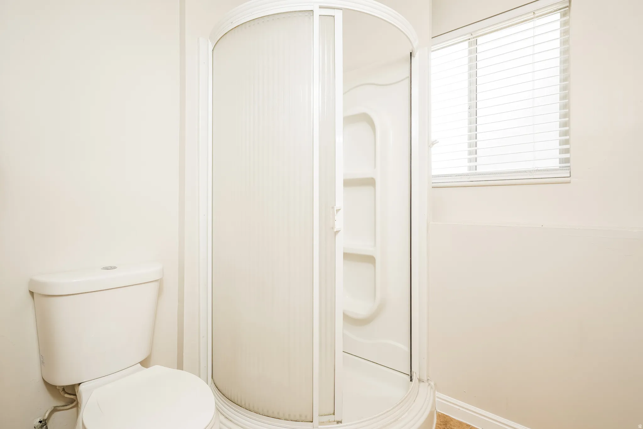 White corner shower with frosted glass enclosure
