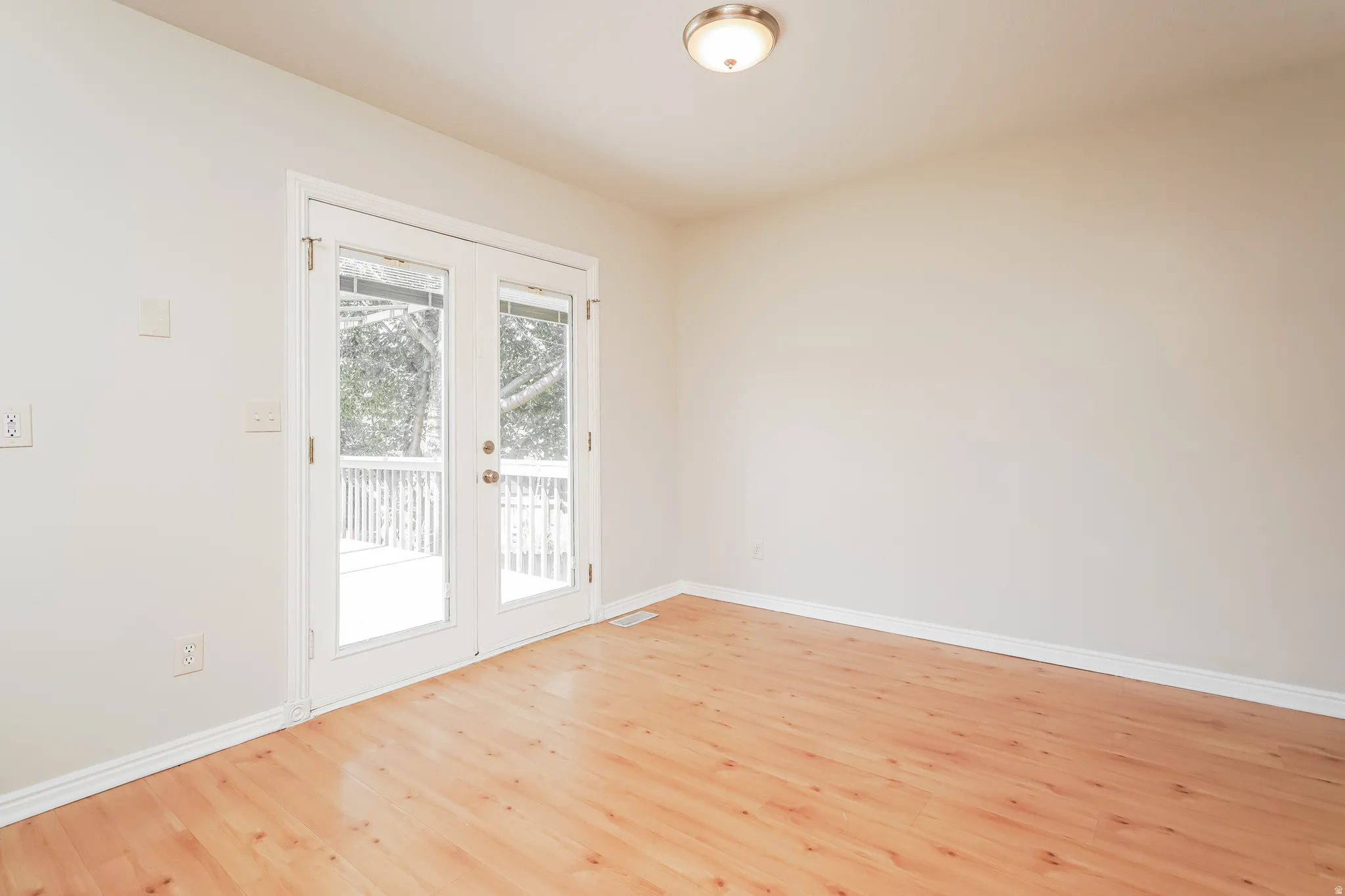 Interior room featuring light wood-finish flooring and neutral wall tones