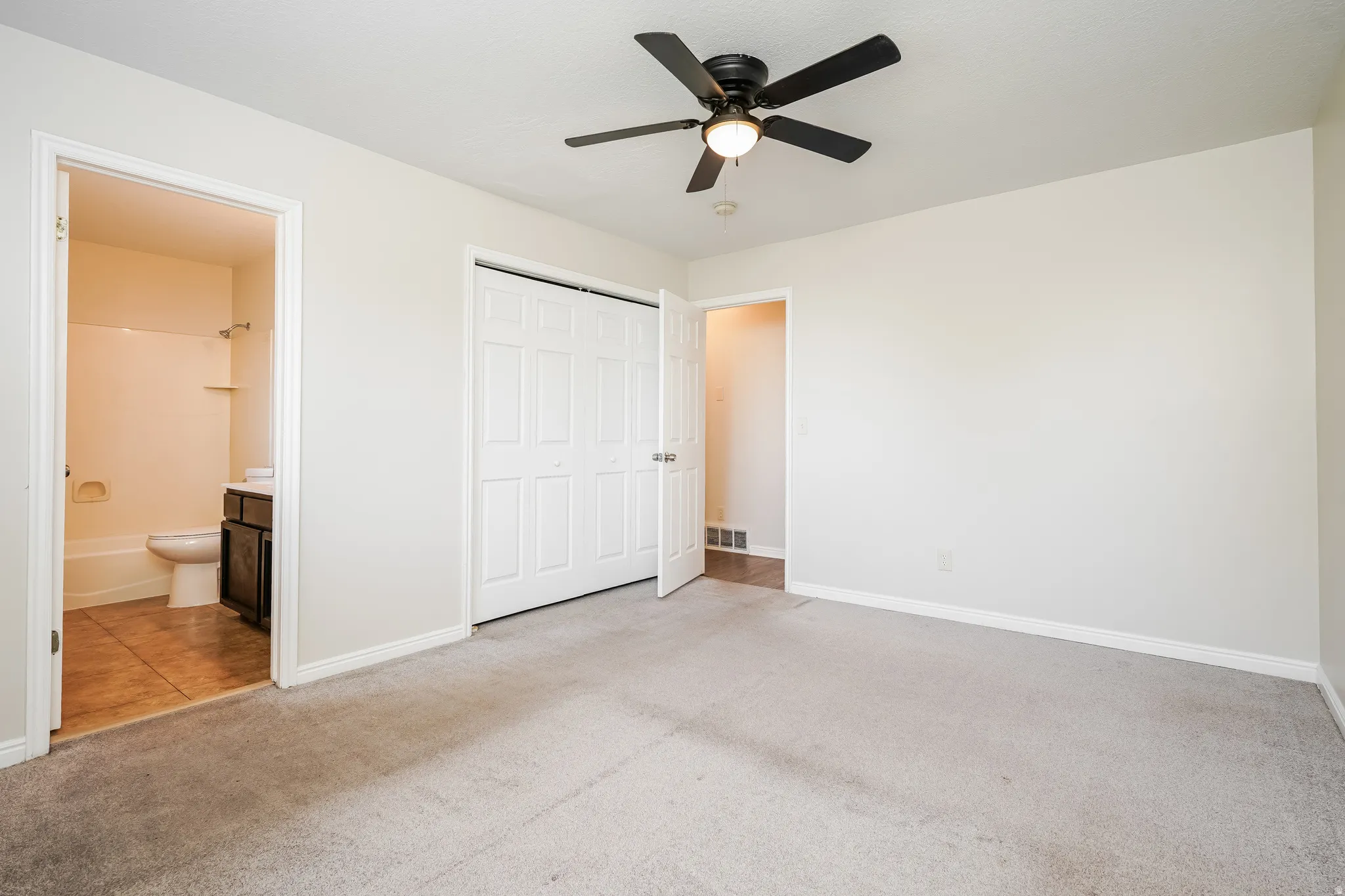 Bedroom featuring light gray carpeting, neutral wall finishes, and a ceiling fan with integrated lighting