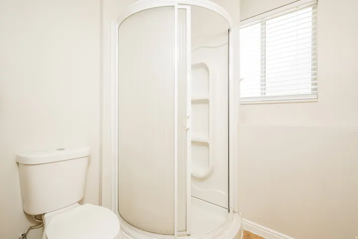 White corner shower with frosted glass enclosure