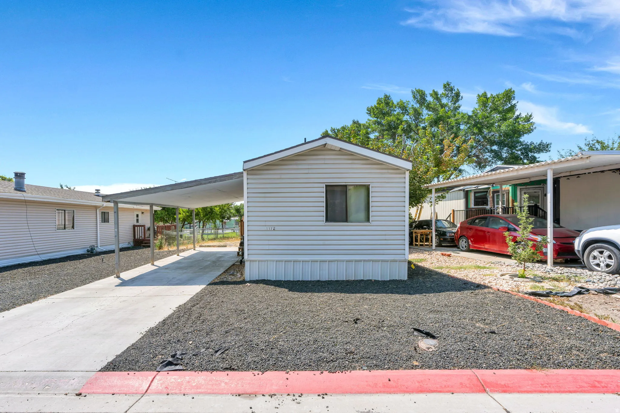 Siding exterior with carport and concrete driveway