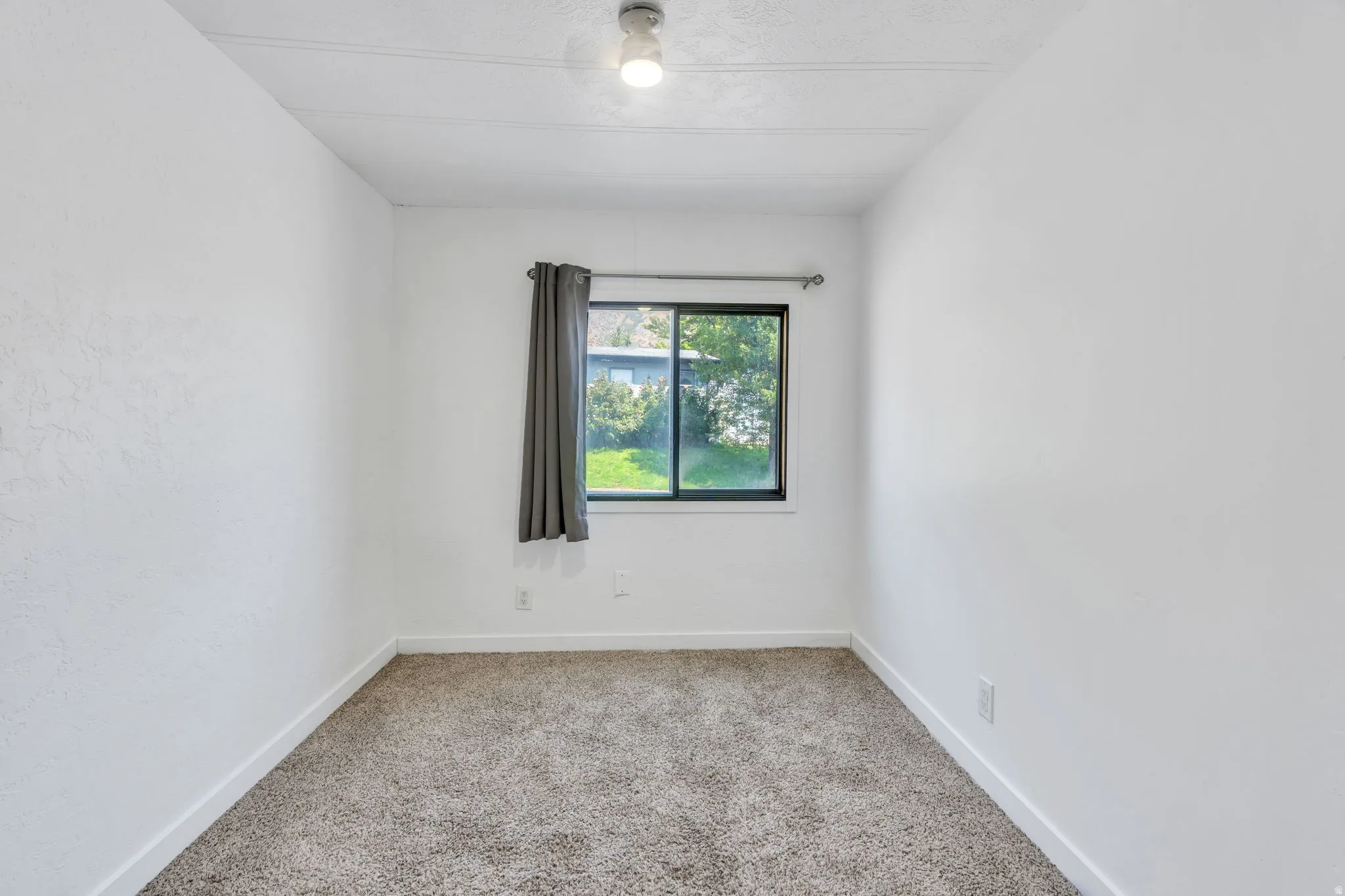 Recessed window with dark framing and a single ceiling light fixture