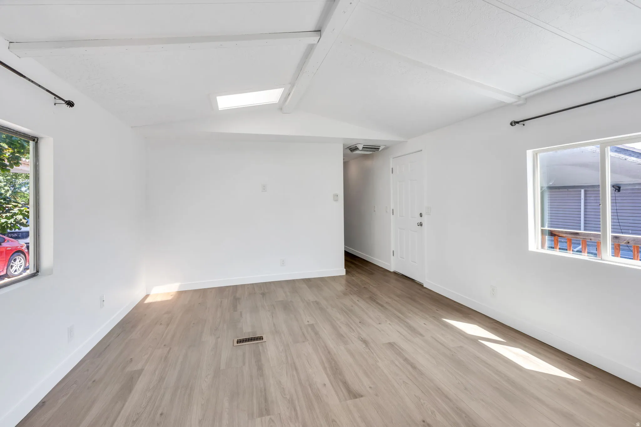 Wood-finish flooring, white walls, and a skylight