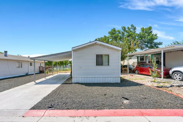 Siding exterior with carport and concrete driveway