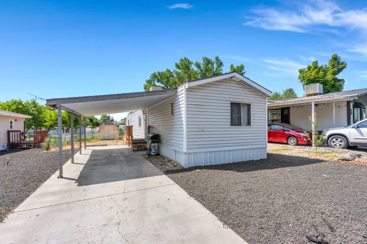 Exterior featuring horizontal siding, a covered carport, and a concrete driveway