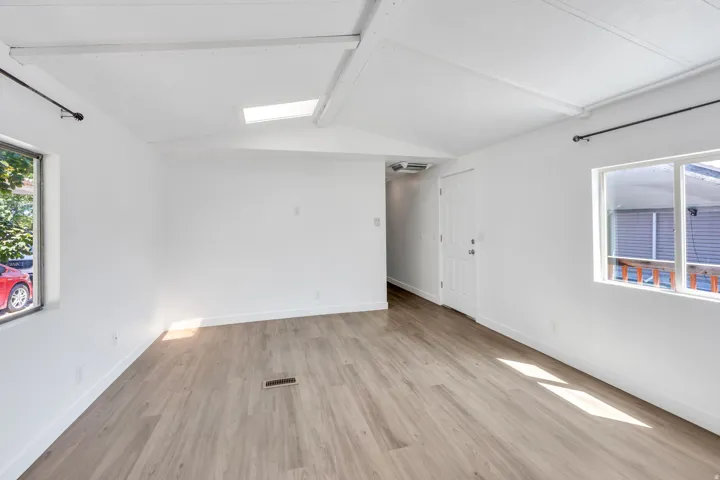Wood-finish flooring, white walls, and a skylight