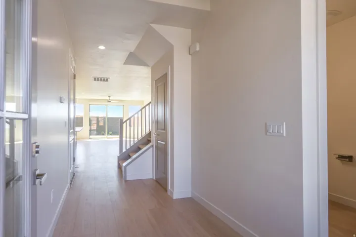 Foyer with light wood-finish flooring, recessed lighting, and a contemporary staircase with white risers and a light wood-finish handrail