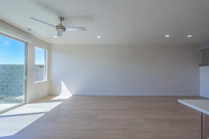 Open concept living area featuring light wood-finish flooring, a contemporary ceiling fan, and recessed lighting