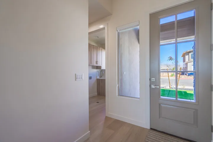 Entryway featuring a paneled door with multiple glass lites, a frosted sidelight, and light wood-finish flooring