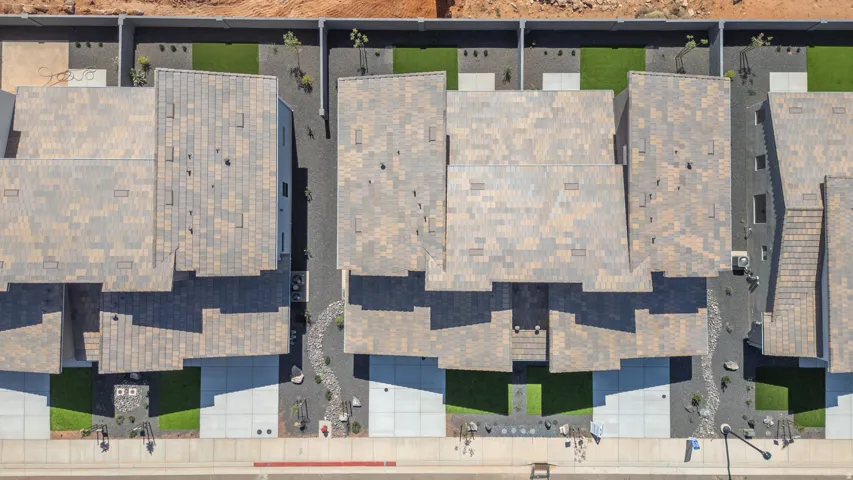 Aerial view showcasing a row of modern residential townhomes with distinctive pitched rooflines finished in composite shingles