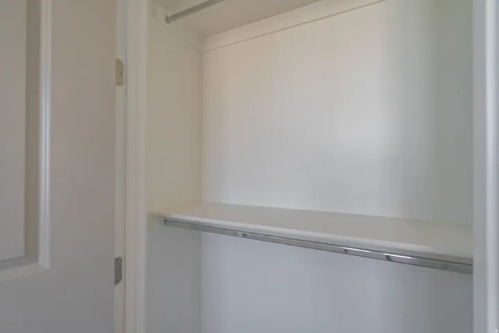 Built-in closet system featuring a shelf and chrome hanging rod
