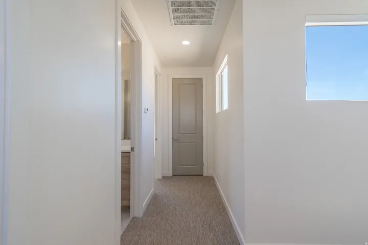 Hallway with light gray carpet flooring and recessed lighting