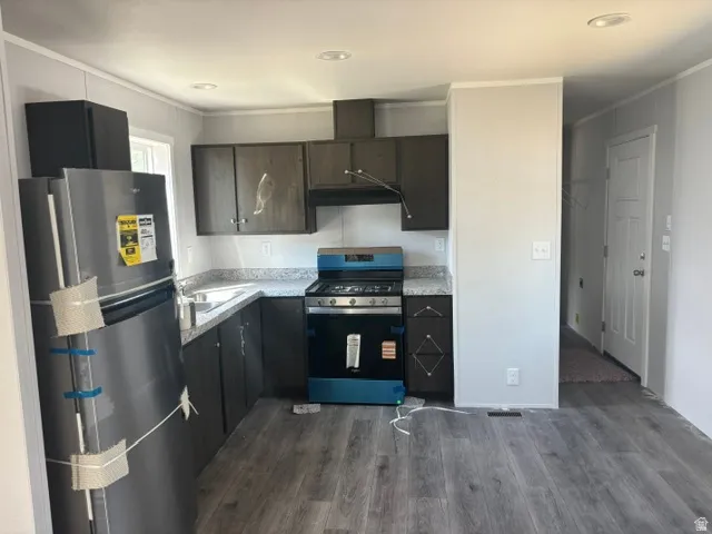 Modern kitchen featuring stainless steel appliances, including a gas range and French-door refrigerator with ice and water dispensers