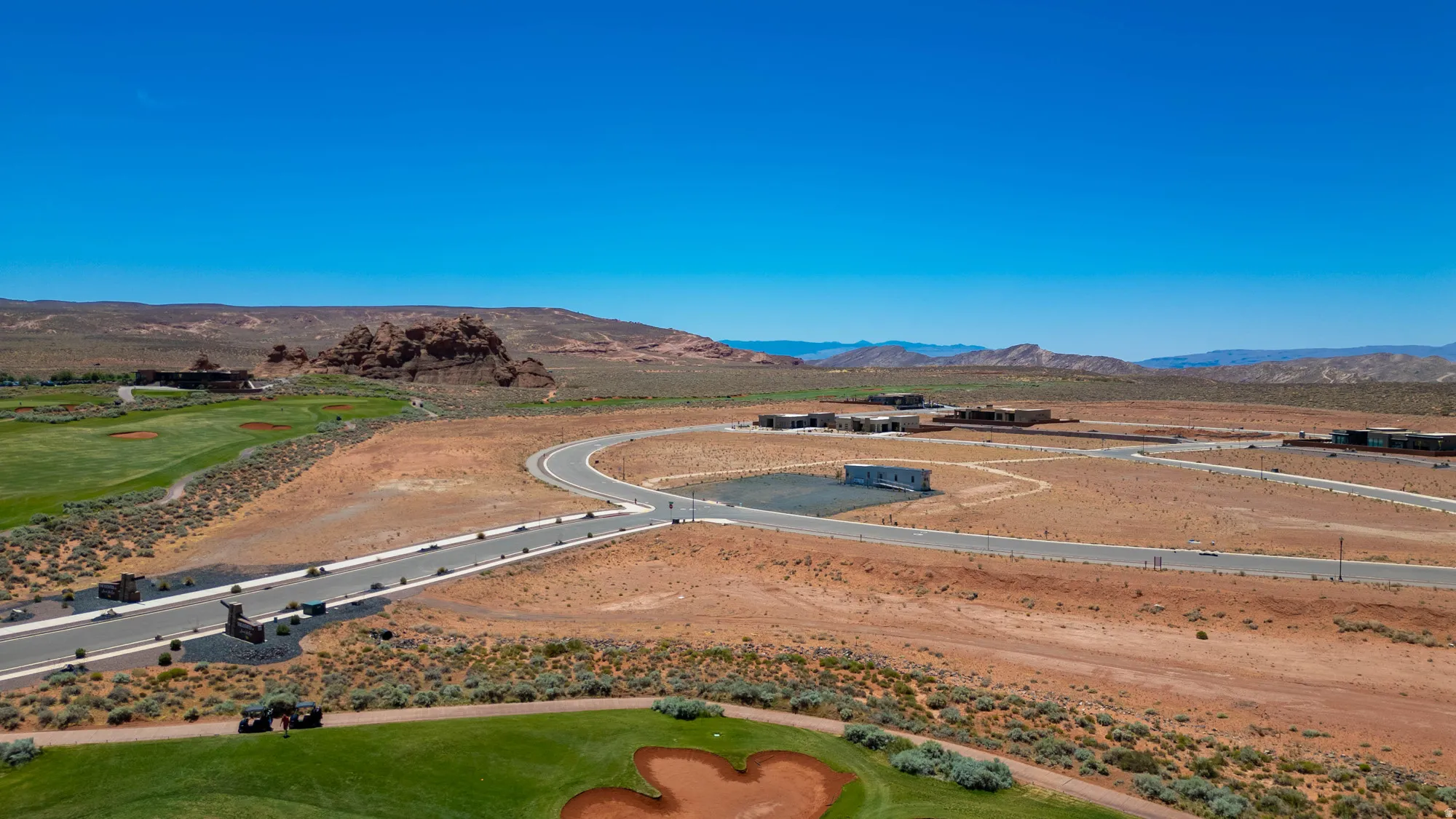 Expansive desert terrain featuring a paved road system and multiple building sites