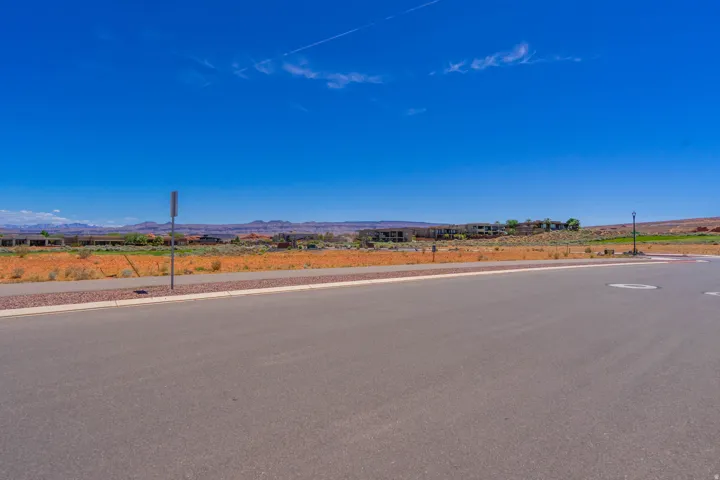 Vacant residential lot with paved frontage and clear sightlines to distant mountain ranges