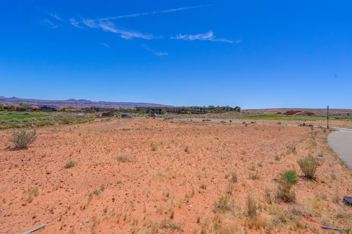 Expansive vacant land with red earth soil and sparse native vegetation
