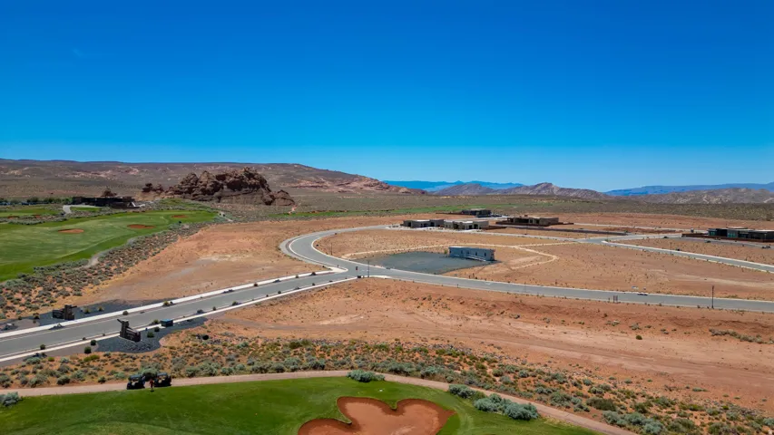 Expansive desert terrain featuring a paved road system and multiple building sites
