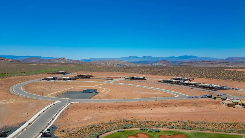 Aerial view of this expansive property showcasing a distinctive circular design with modern infrastructure, paved access roads, and manicured grounds