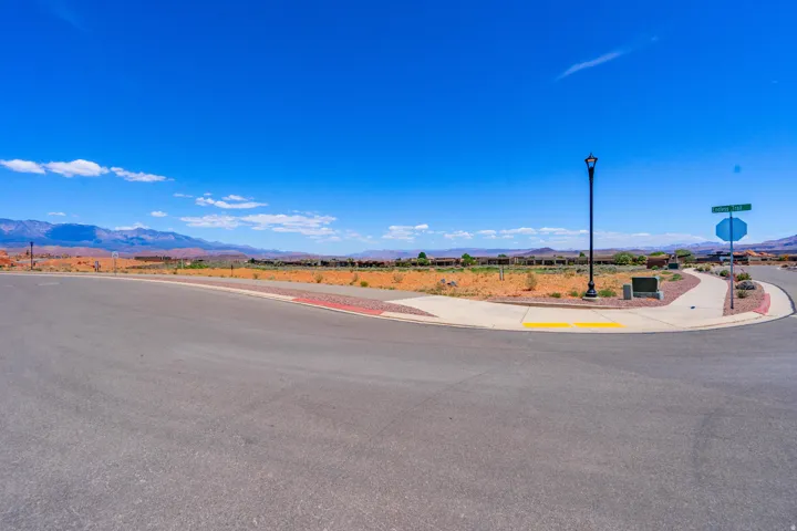 Expansive paved lot with curved red and yellow striping, modern street lighting, and directional signage