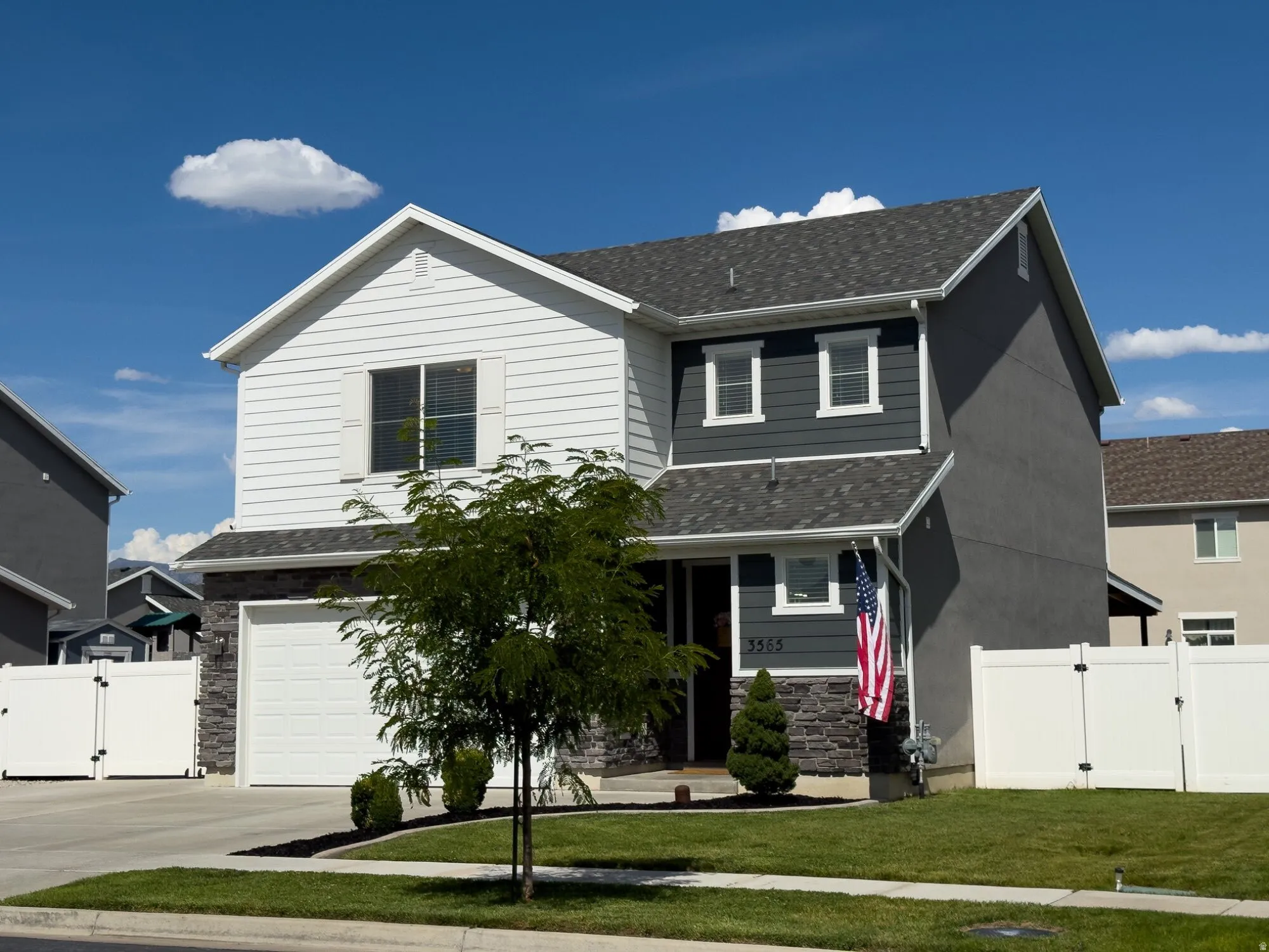 Modern two-story home featuring a clean-lined architectural design with contrasting white and charcoal exterior siding