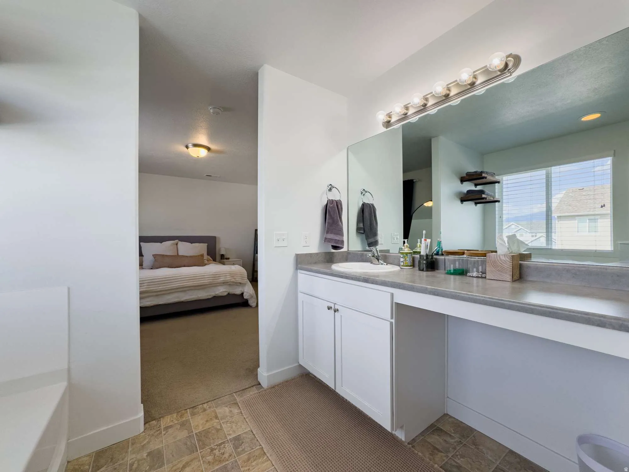 Spa-inspired primary bathroom featuring a double vanity with white cabinetry and brushed nickel fixtures