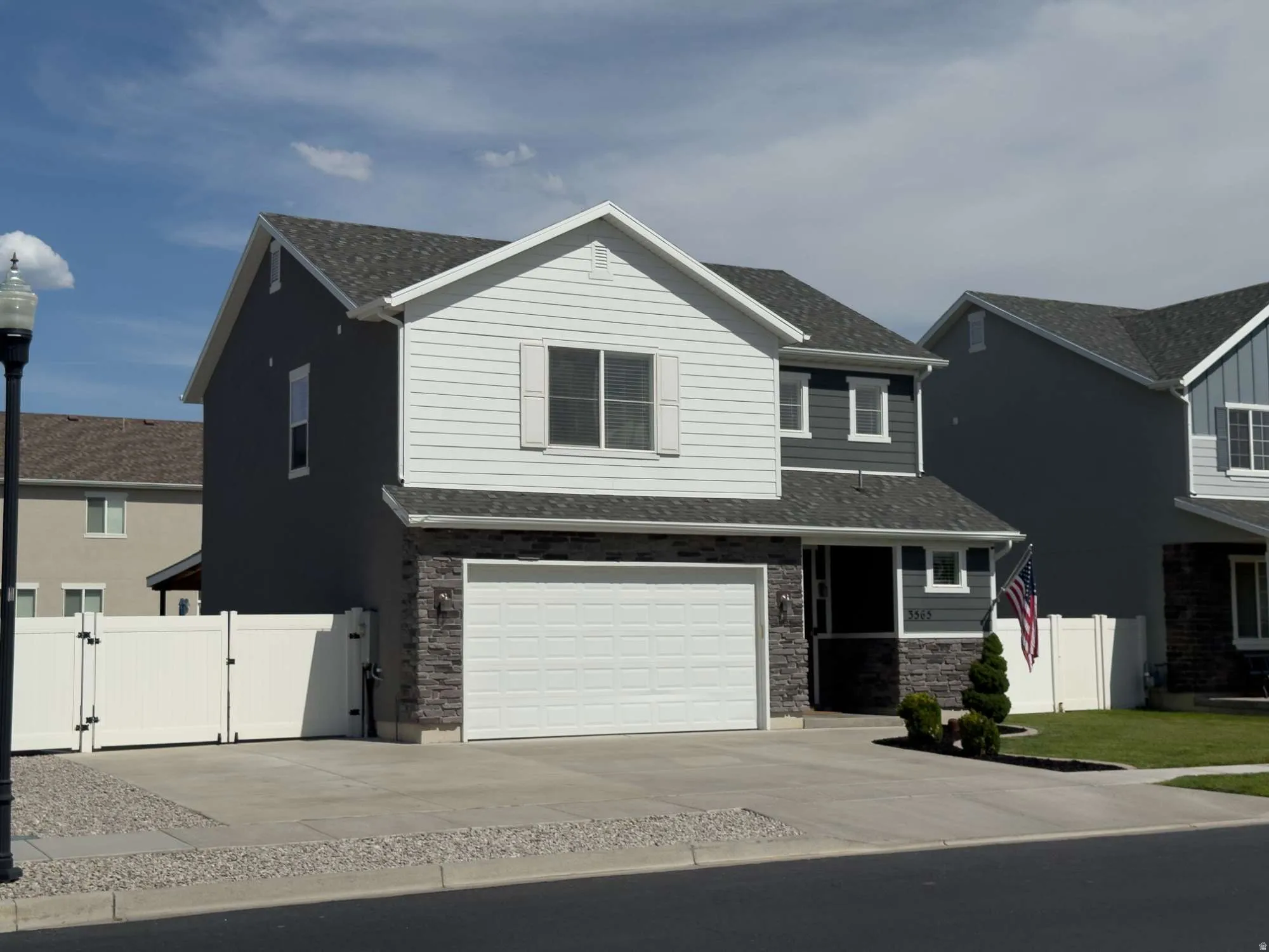 Contemporary two-story residence featuring a two-tone exterior with white siding and dark gray stucco