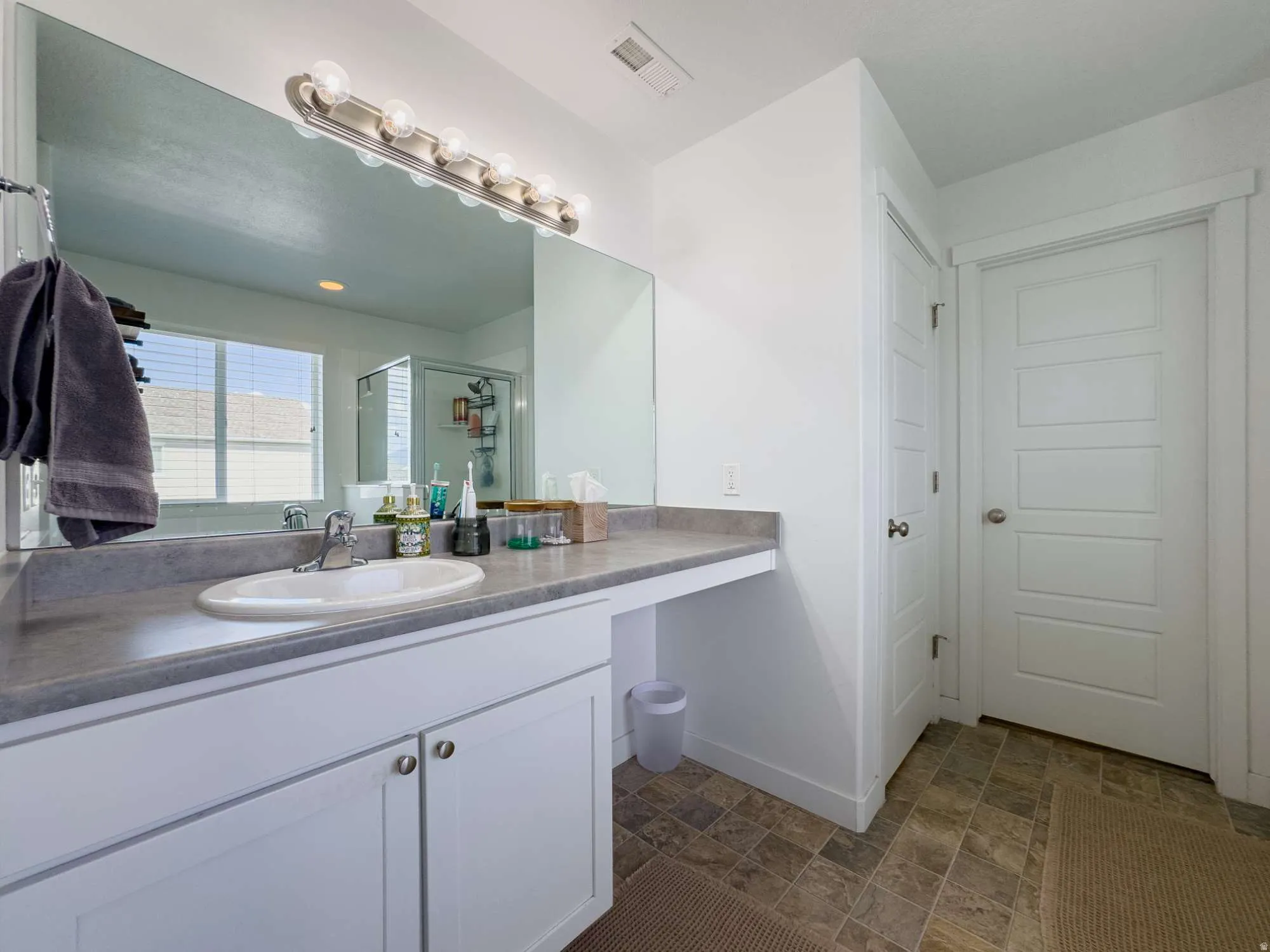 Master Bathroom featuring a large vanity with an integrated sink, ample countertop space, and white cabinetry
