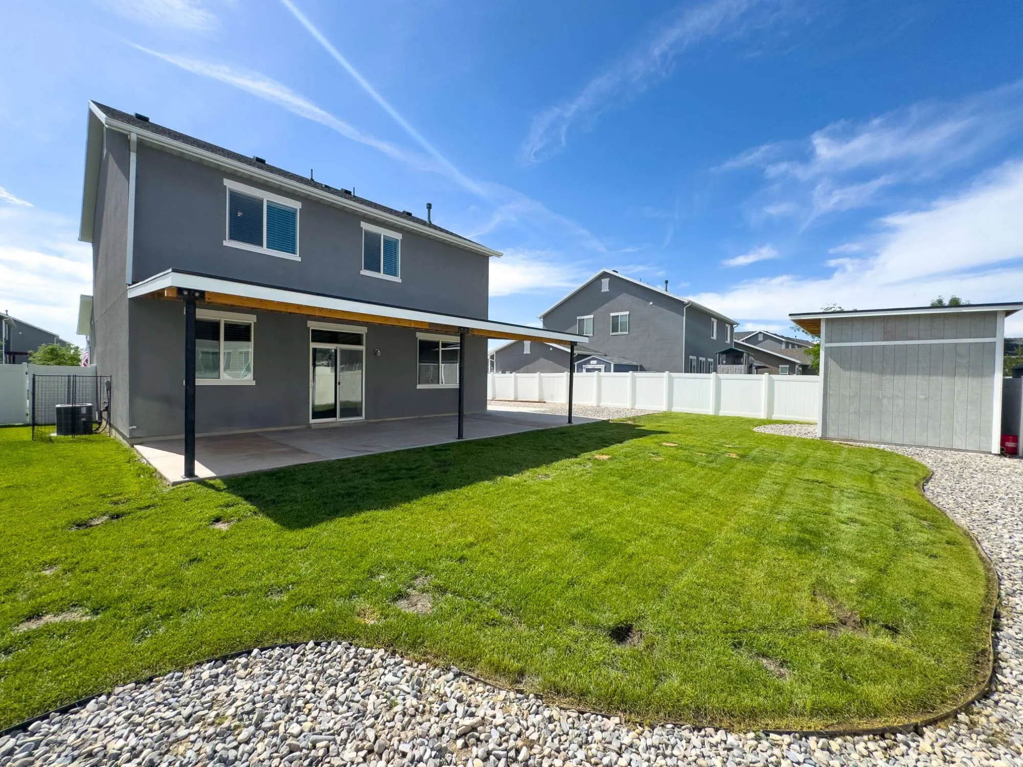 Two-story stucco exterior featuring a covered patio, sliding glass door access