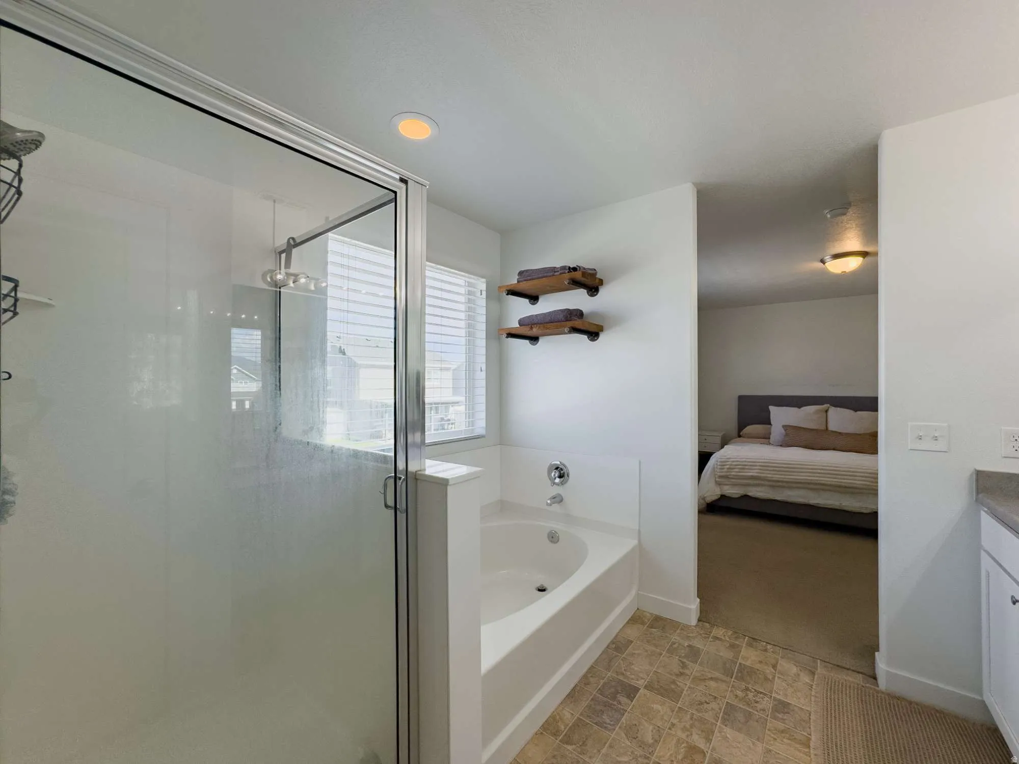 Shower with glass enclosure, separate tub, and window with blinds