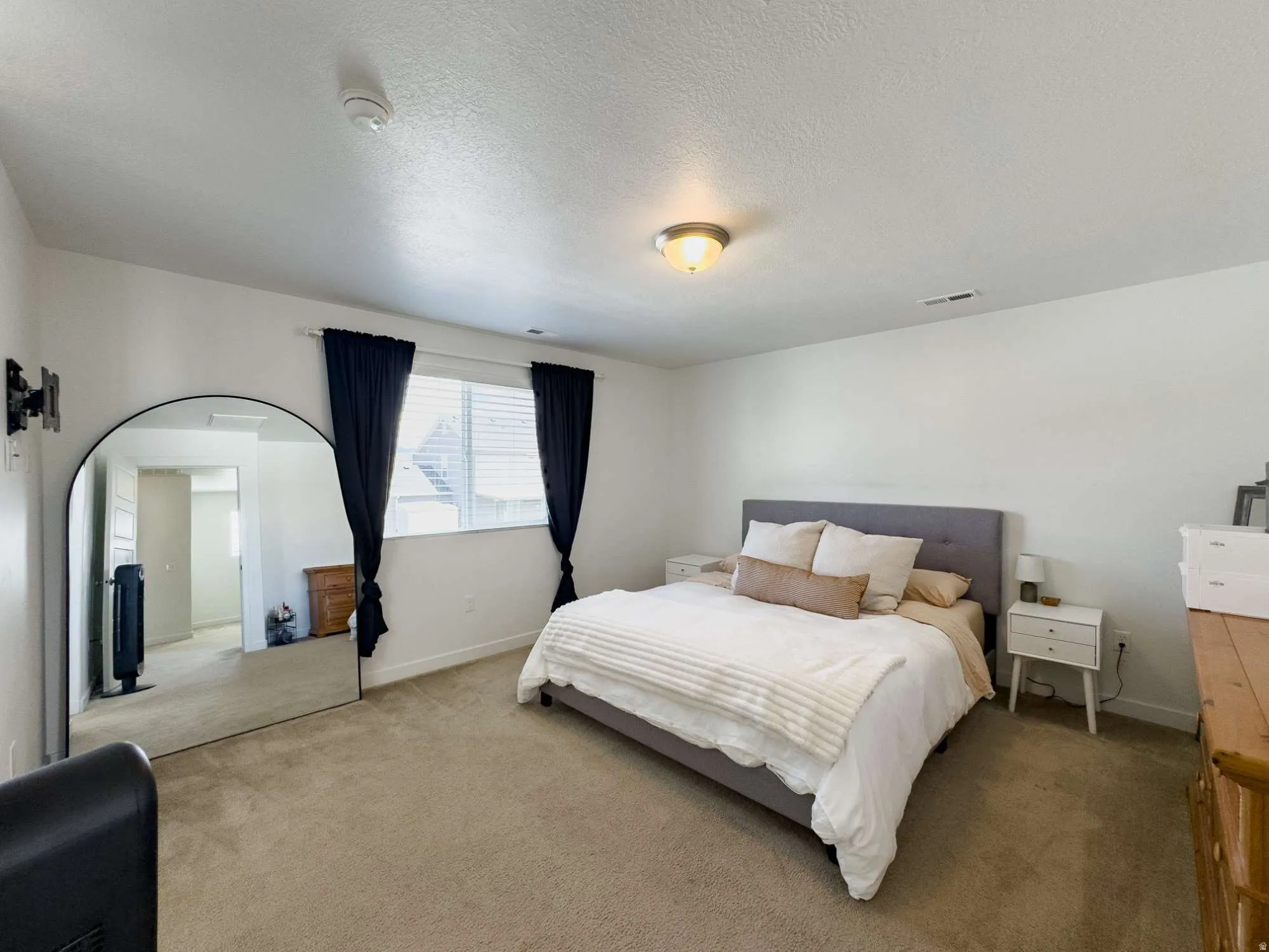 Spacious primary bedroom featuring carpeted flooring, and abundant natural light from dual windows