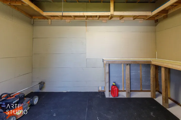 Storage shed interior including electric lighting and built in work bench.