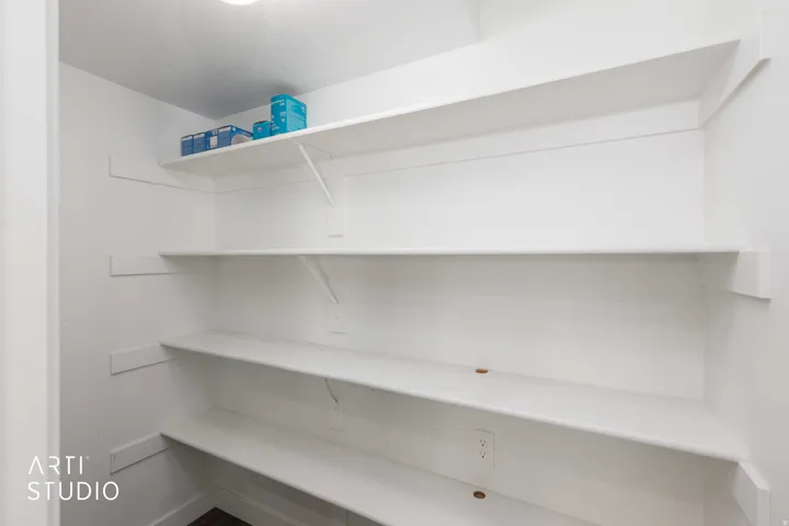 Built-in shelving with white finish, recessed ceiling lighting, and power outlets