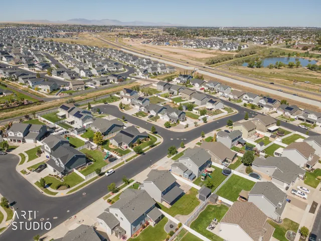 Residential neighborhood featuring detached homes with varied architectural styles, asphalt roadways, and manicured lawns
