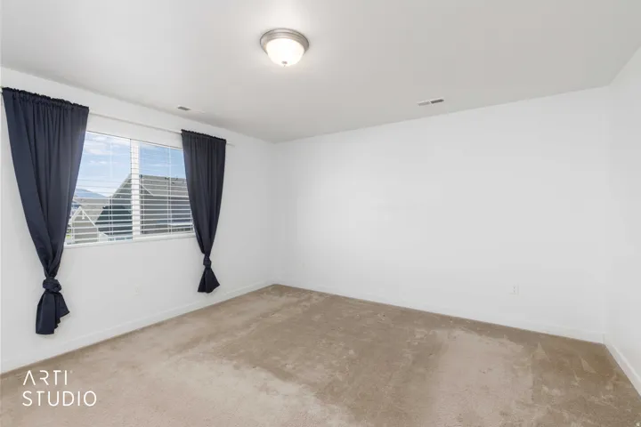 Primary bedroom showing carpet, windows with blinds and mountain views.