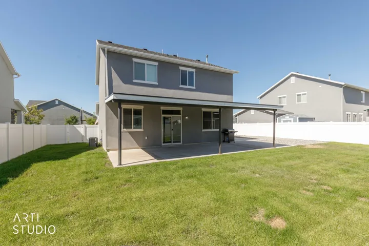 Expansive backyard featuring a manicured lawn, a full-length covered patio, and a privacy fence