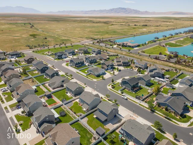 Aerial perspective of a residential community featuring detached homes, paved streets, and landscaped yards
