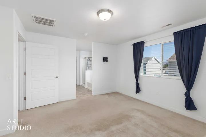 Primary bedroom, carpet flooring, white walls, and a multi-pane window with horizontal blinds
