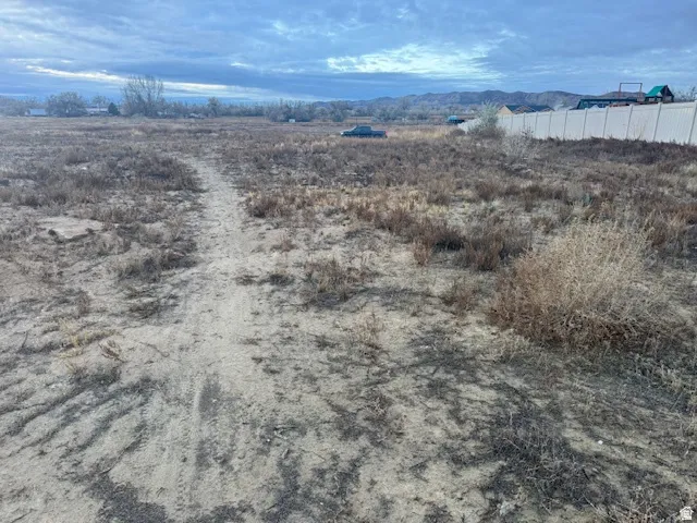 Expansive land parcel featuring natural terrain and distant mountainous backdrop