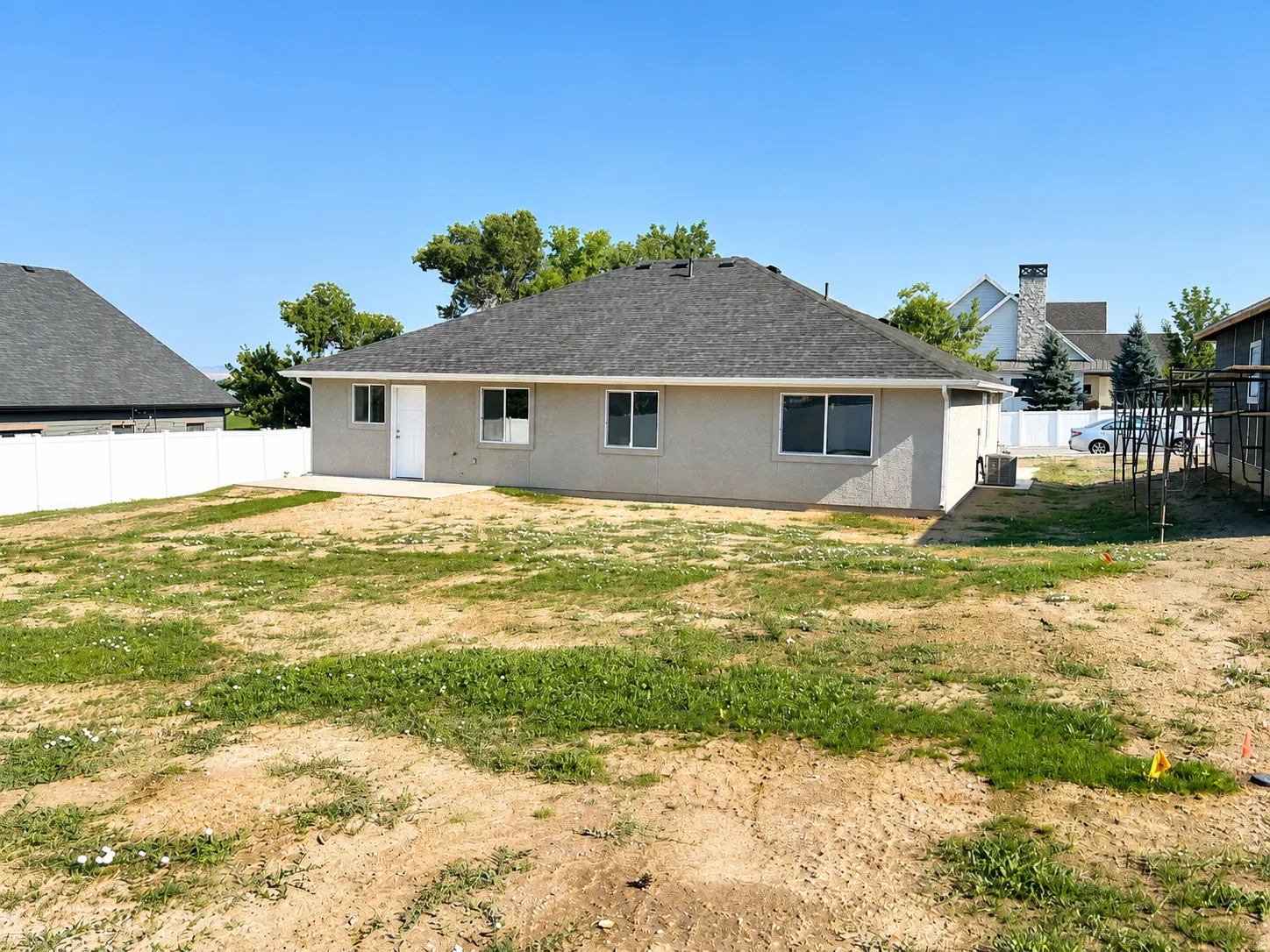 Rear exterior featuring stucco siding, multiple windows, and a white outdoor access door