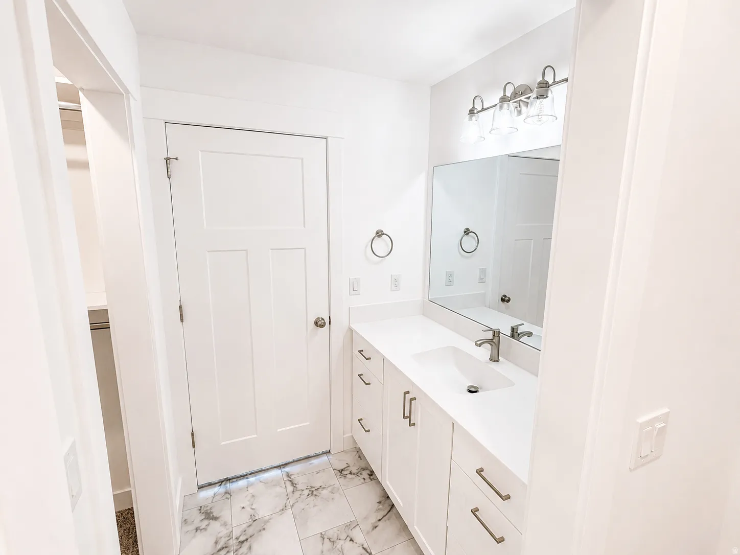 Master bathroom white vanity with integrated sink, brushed nickel faucet, and quartz countertop