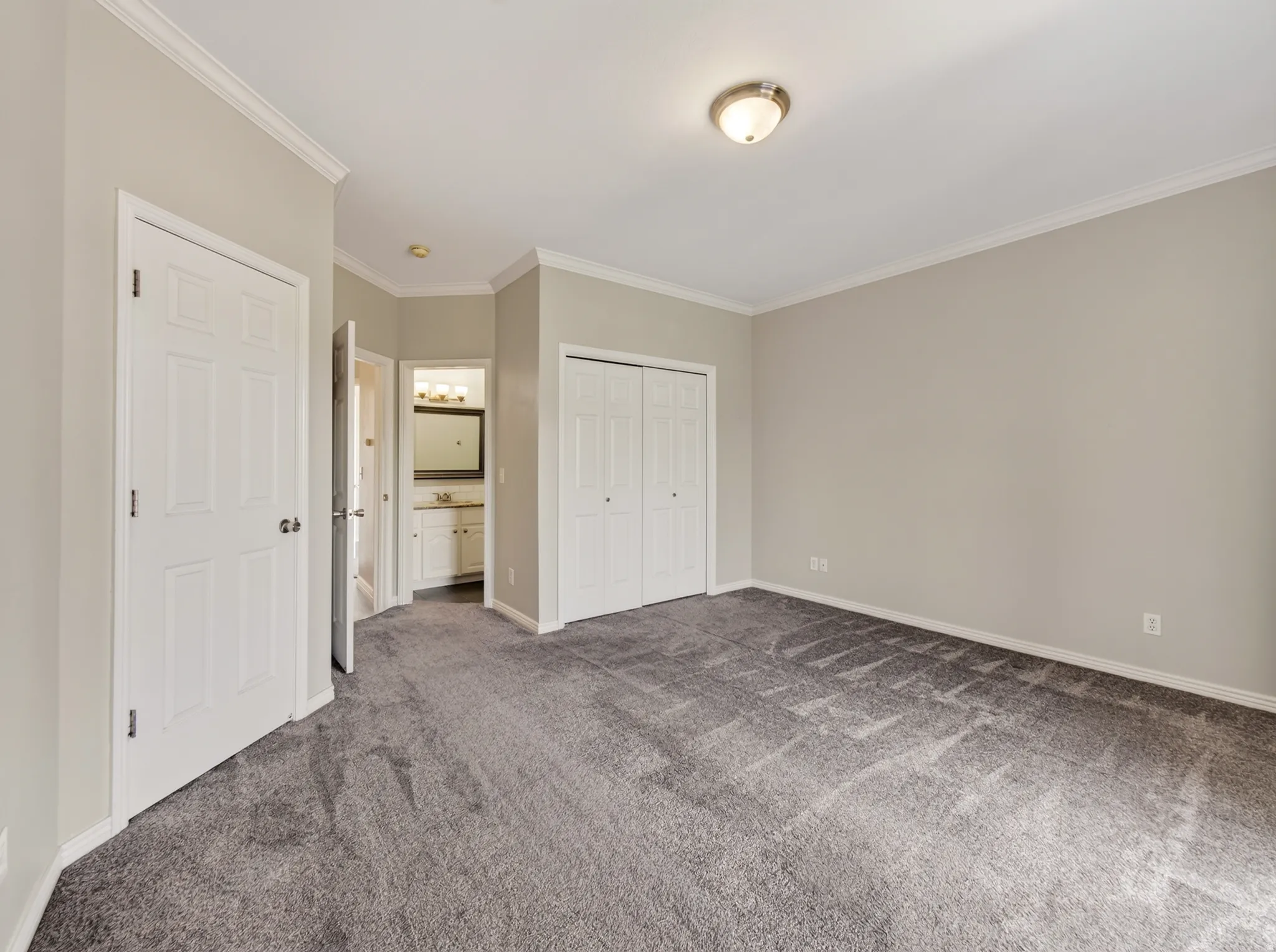 Spacious room featuring neutral carpeting and light gray wall paint