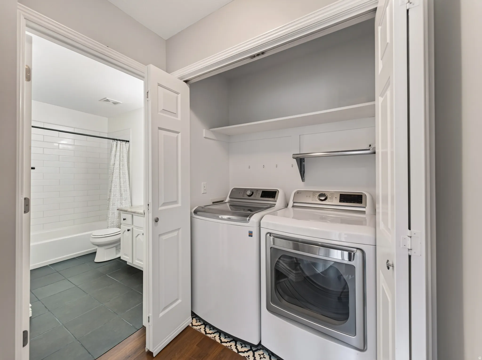 Convenient laundry closet with built-in shelving, hanging rod, and appliances