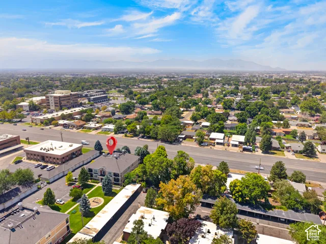 Aerial overview showcasing a multi-story building with a dark roof and surrounding green spaces