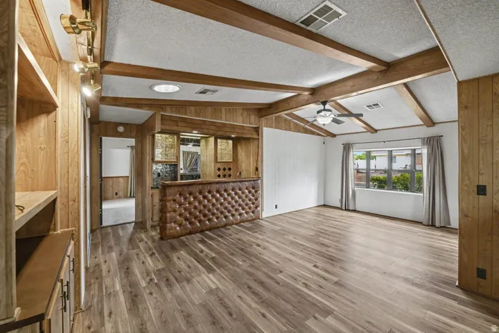 Spacious interior featuring wood-finish flooring, exposed ceiling beams, and recessed lighting